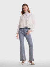 Woman wearing white cardigan and jeans and high heels